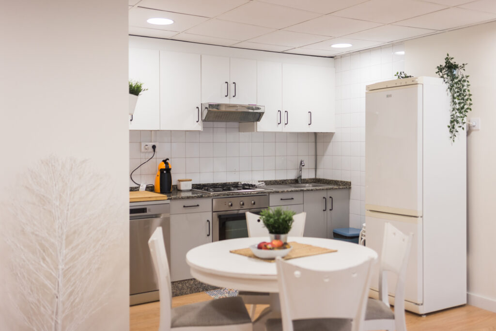Cocina equipada con mesa redonda blanca y nevera