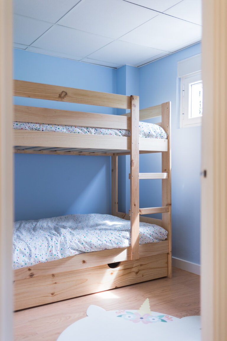 Litera de madera en habitación infantil con pared azul
